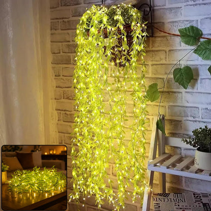 A hanging basket with long strands of green leaf string lights cascading down a brick wall, illuminated.