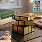 A gold mirror cube puzzle sits on a dark brown desk next to books and a lamp, with a small inset of a child playing with the