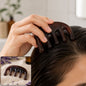 A woman's hand uses a dark brown resin scalp massager on her wet hair, with a smaller inset image of the massager on a towel