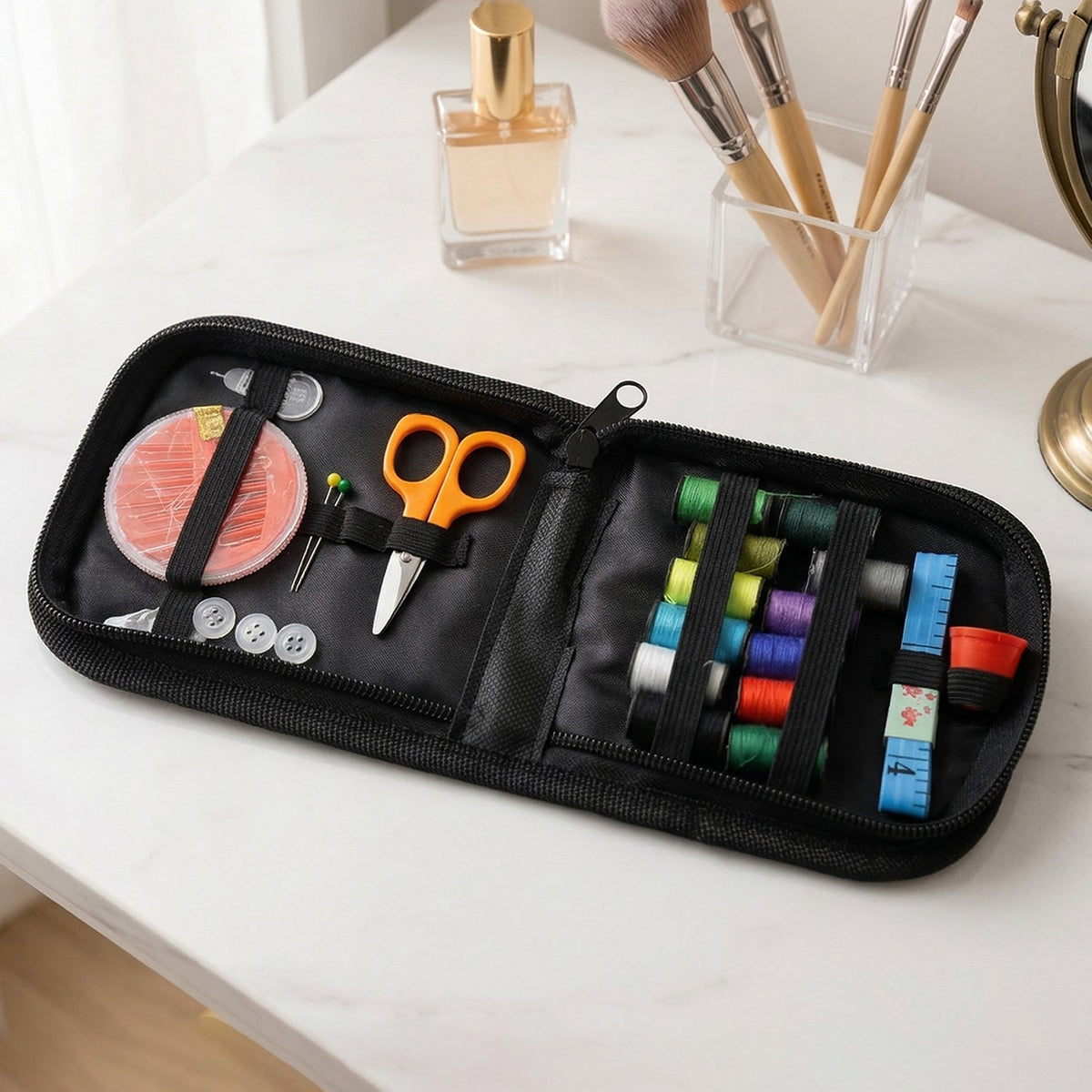 An open black zippered sewing kit with colorful threads, orange scissors, and other accessories is displayed on a white