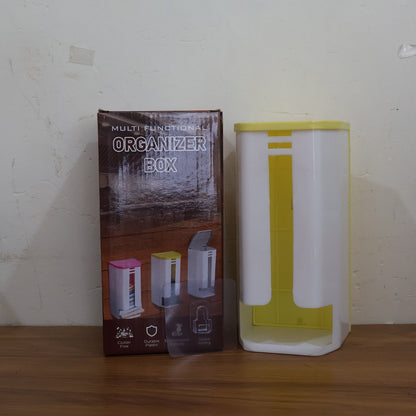 A white and yellow plastic bag dispenser sits next to its