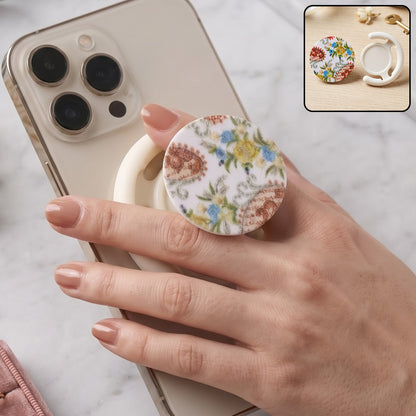 A hand holds a white smartphone with a round pop socket featuring a white background and colorful paisley floral – view 8