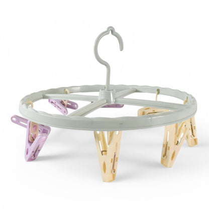 A light blue circular drying rack with purple and yellow clips is shown against a plain white background.