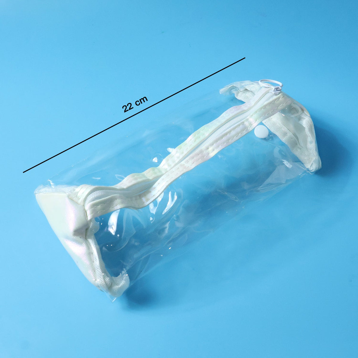 Empty clear PVC pencil case with white trim and zipper on a blue background, with a 22 cm measurement line.