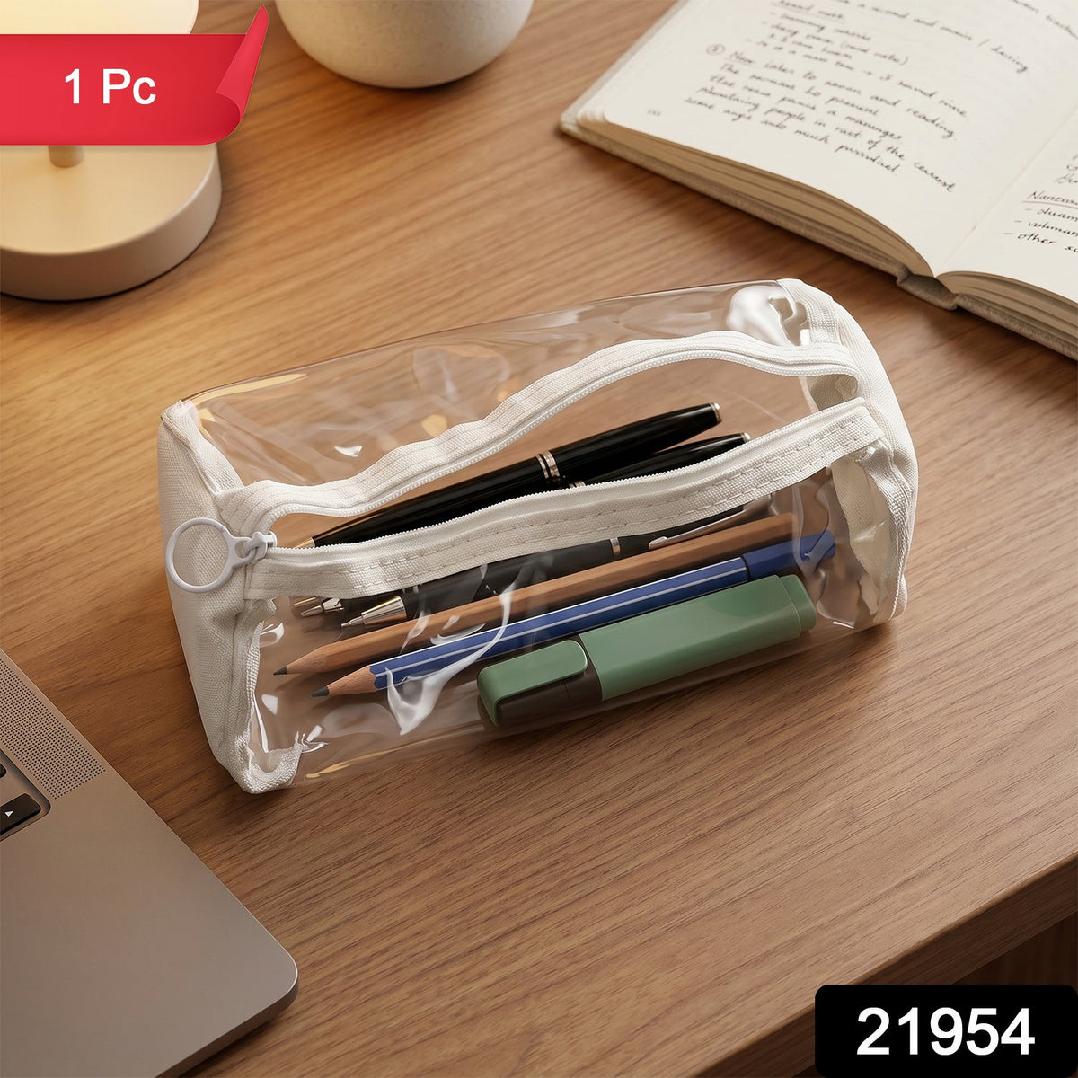 Clear PVC pencil case with white trim, filled with pens and pencils, on a wooden desk with a notebook.