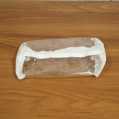 Empty clear PVC pencil case with white trim and zipper, centered on a light brown wooden surface.