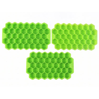 Three identical bright green silicone ice cube trays, each with a honeycomb pattern, are arranged on a plain white