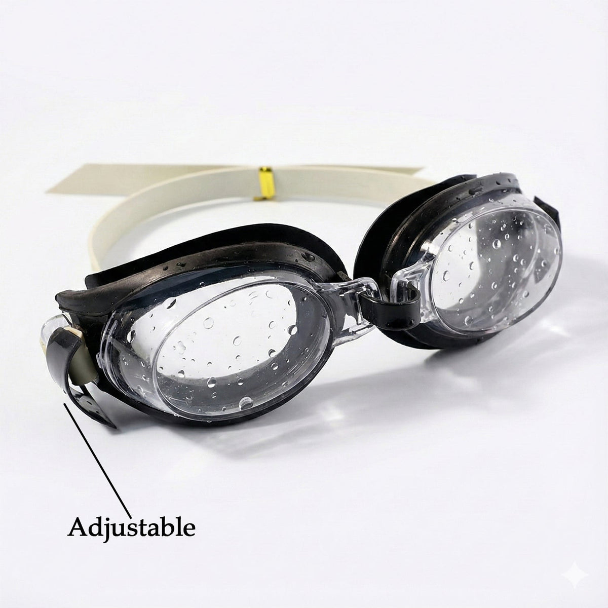 Black and clear swimming goggles with a beige strap on a white background, with an arrow pointing to the adjustable strap.