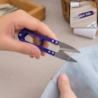 A person's hands hold blue thread snips, trimming the edge of light blue fabric, with an inset showing the snips and thread.
