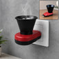 A red and black electric Kapoor Dani diffuser plugged into a white wall socket, emitting smoke.