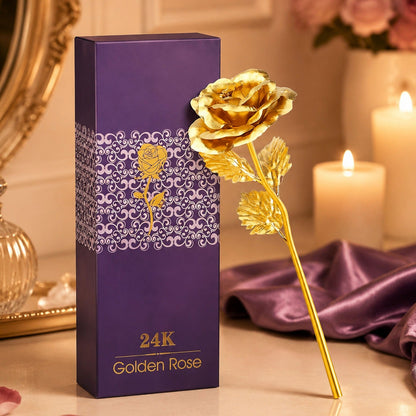 A gold-plated rose stands next to a purple gift box with a patterned design and gold text.