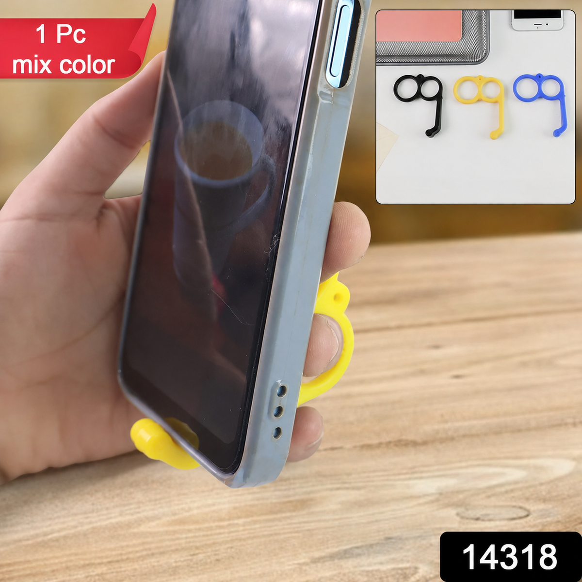 A hand holds a phone with a yellow finger ring phone holder supporting it from below.