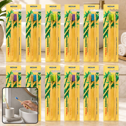 Twelve twin packs of bamboo toothbrushes with various colored bristles, arranged on a bathroom counter with an inset image.