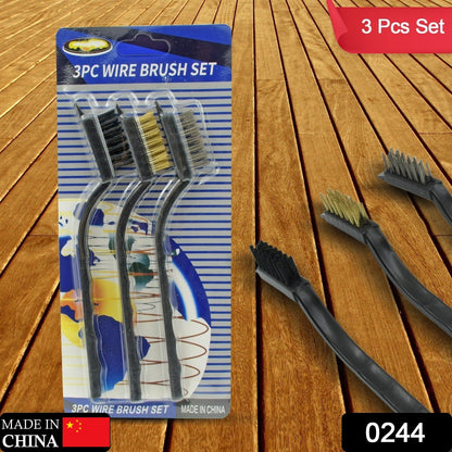 Three mini wire brushes in blister packaging on a wooden surface, with loose brushes to the right.