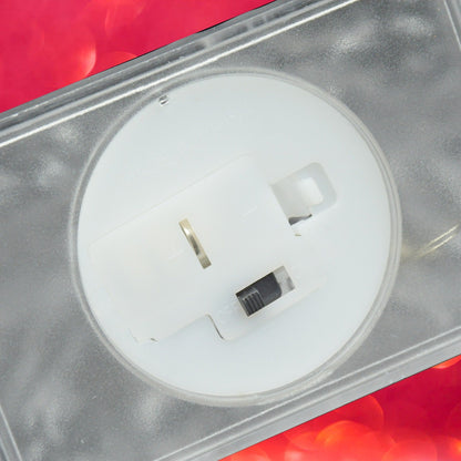 A close-up of the bottom of the clear LED iceberg light reveals a white battery compartment with an on/off switch.