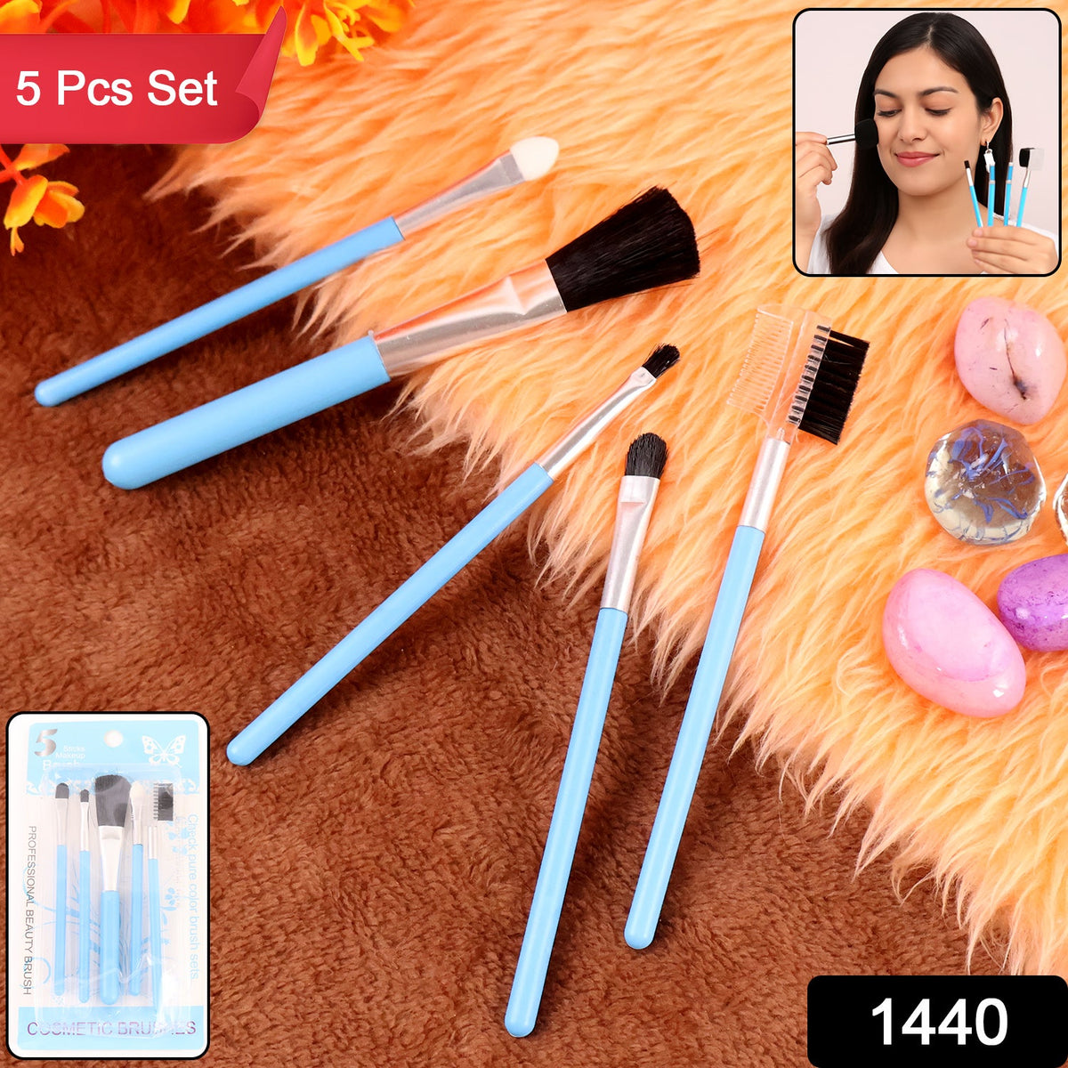 Five light blue makeup brushes are arranged on an orange furry surface, with a small inset of a woman using a brush.