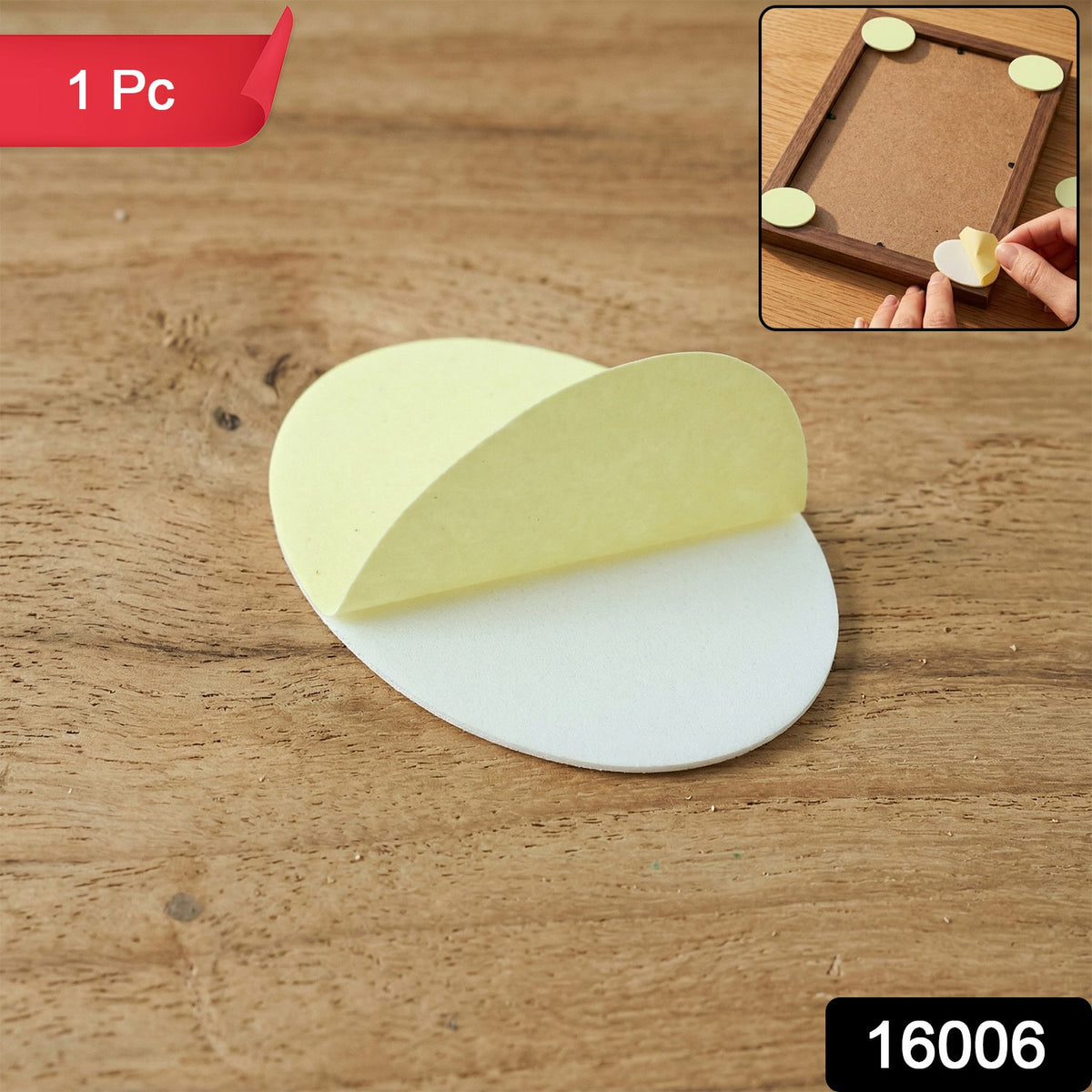 A single white oval pad with its yellow adhesive layer partially peeled, resting on a wooden surface.