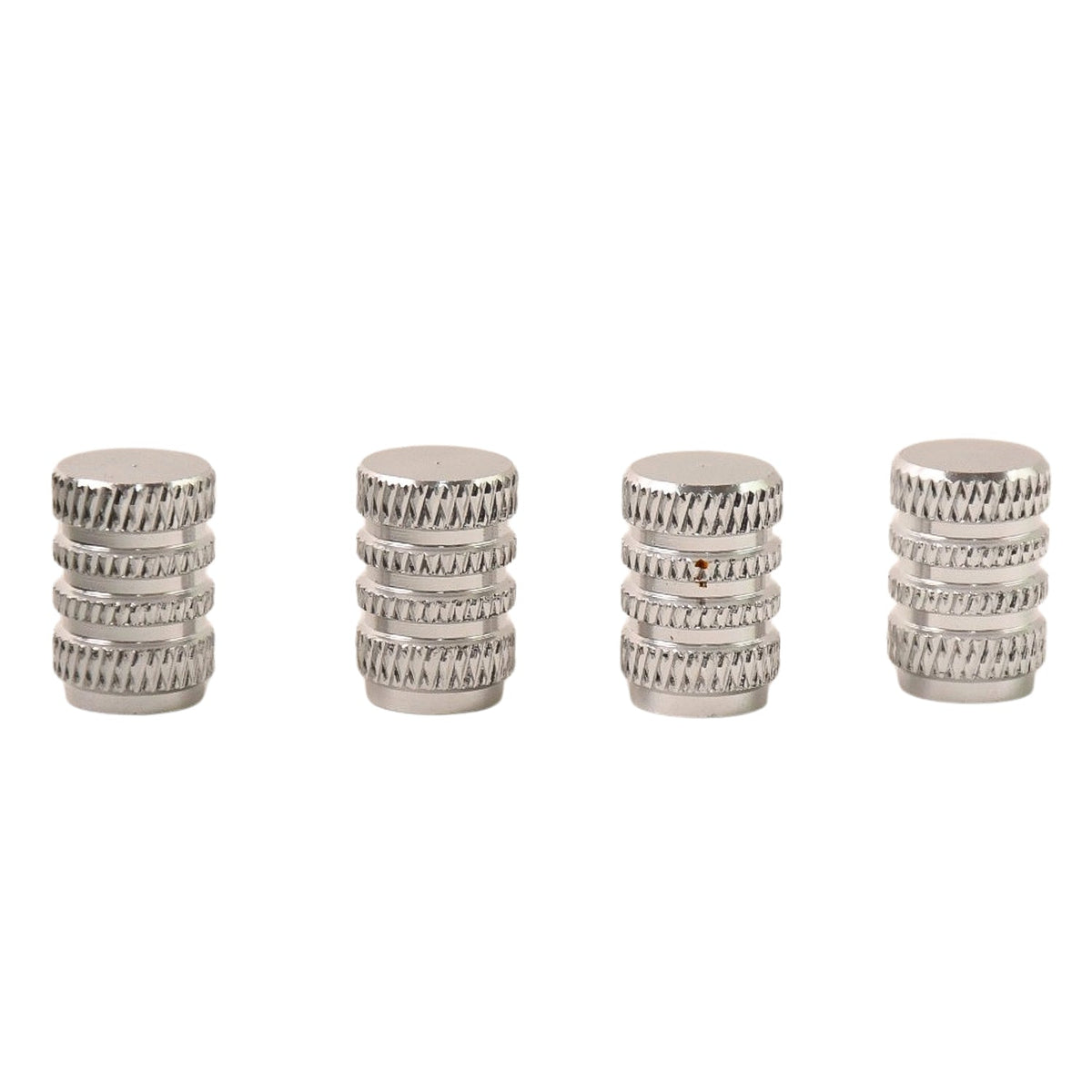 Four silver, textured, cylindrical valve caps standing upright on a white background.